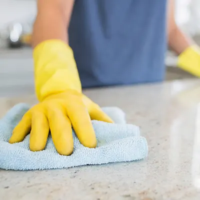 Maid wiping kitchen countertops