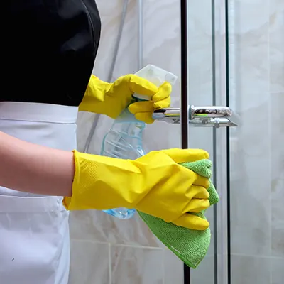 Maid cleaning a bathroom shower