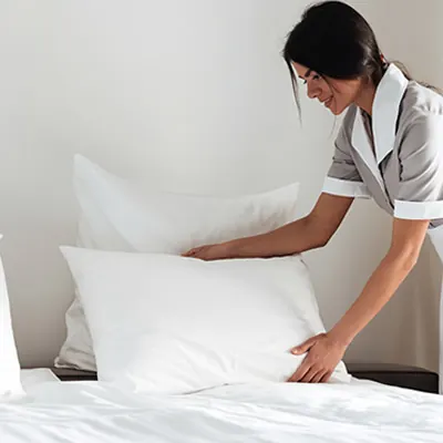 Maid making a bed for the next vacation rental guest